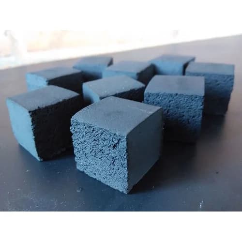 Coconut shell charcoal cubes on a table, showing the fine-grained cut face